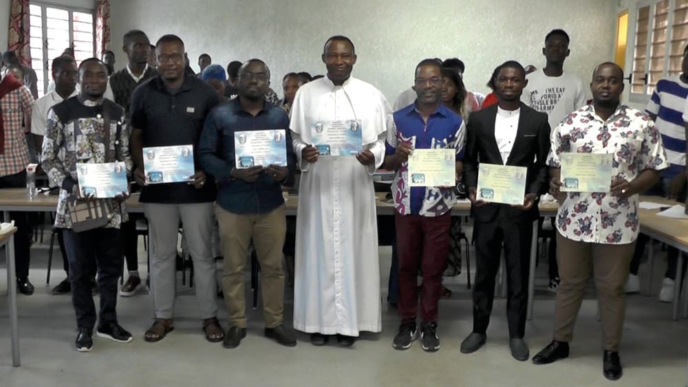 L’abbé Clément Aboudi entouré de plusieurs des nouveaux diplômés.